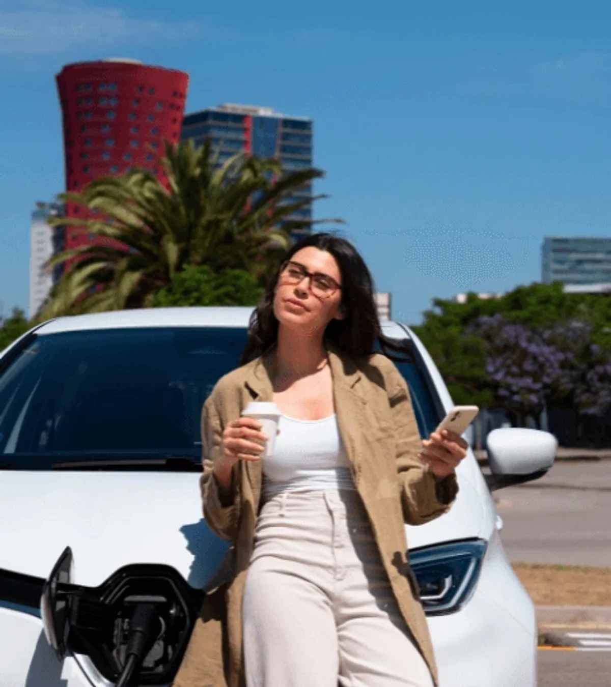 Femme attendant la recharge de sa voiture électrique en ville